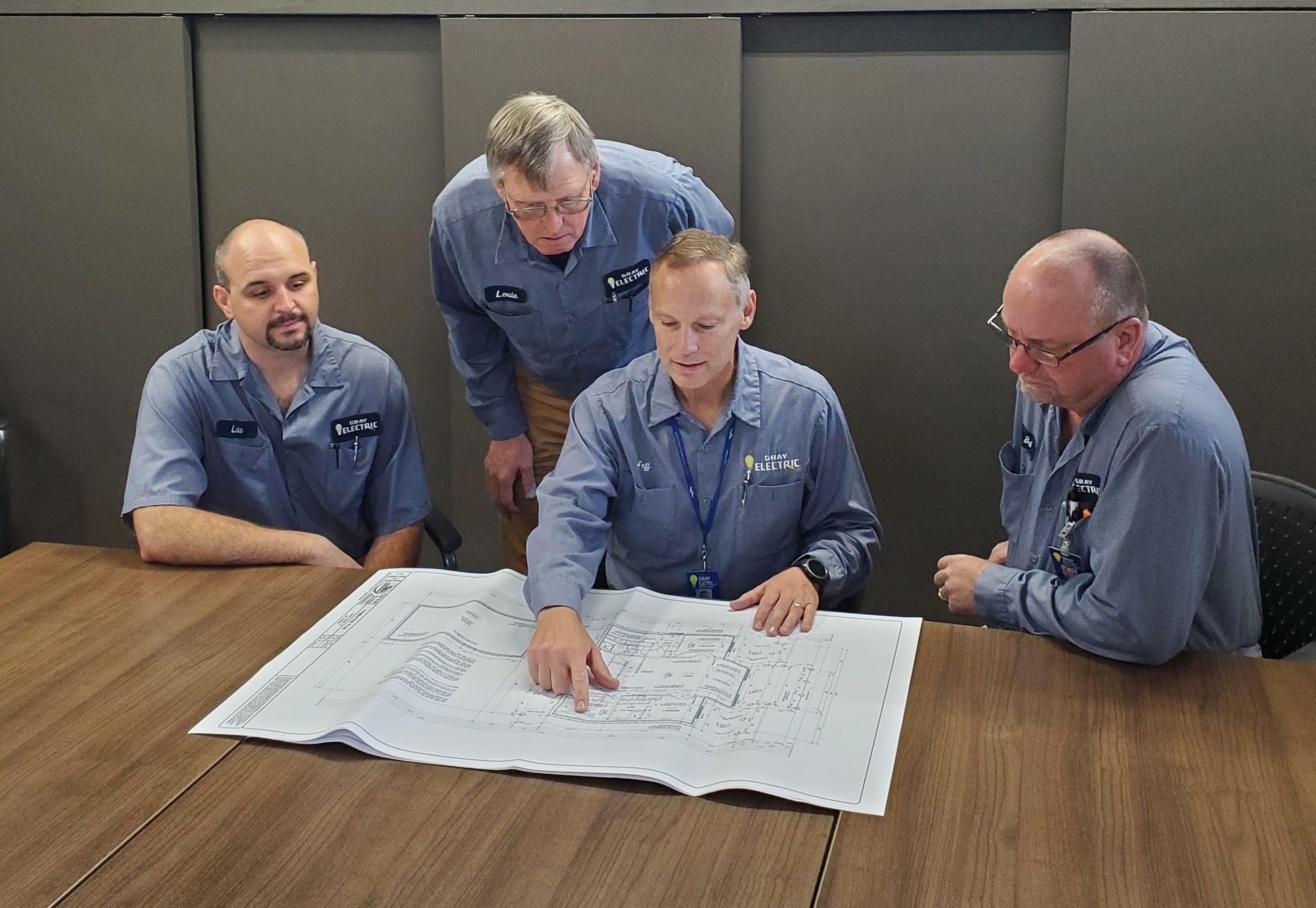 The Gray Electric team reviewing project blueprints